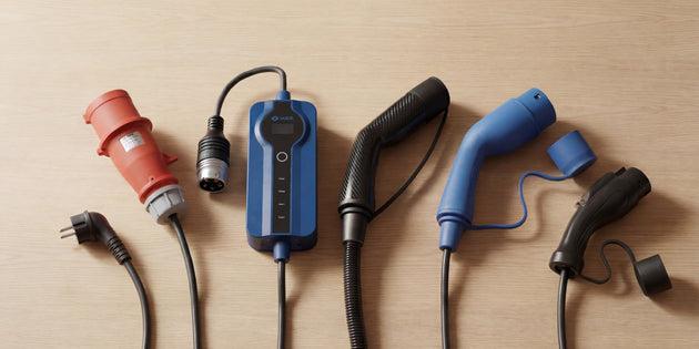 Voldt® EV charging cable range with red CEE plug, control box and Type 2 connectors laid out on wood