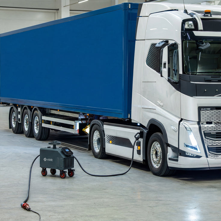 Mobile DC fast charger positioned next to a blue and white electric truck